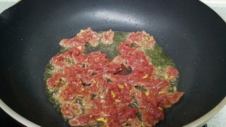 #无肉不欢#凉瓜炒牛肉,炒锅里烧热油,牛肉入锅前加1小勺盐,拌匀,倒入锅里划炒至半熟。盛起。
