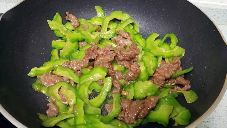 #无肉不欢#凉瓜炒牛肉,倒入牛肉,加一点点清水,略略翻炒一下。