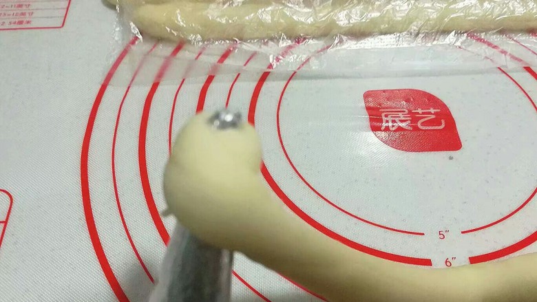 紫薯芋泥螺卷包,取一个螺管模具将起始端压扁,自螺管尖端处开始卷起;