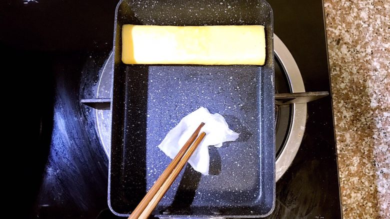 日式厚蛋烧,卷到最上方,第二层蛋卷成型后准备倒入第三层蛋液。这里提一点需要注意的地方,每次倒入蛋液前如果发现锅内油不够了,就用之前吸了橄榄油的厨房吸油纸再在锅内均匀涂抹一层