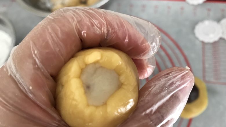 中式月饼~莲蓉&豆沙蛋黄月饼,利用手的虎口处慢慢把饼皮往上推至收口,收口处一定要收紧抹平