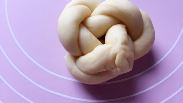 牛奶黑芝麻小餐包,两头接紧,盘成圆形,再把接缝处穿过手指环形捏紧即可。