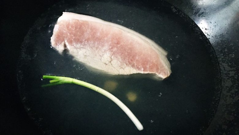 无肉不欢之成都凉拌白肉,先将肉放入水中煮开转小火煮20-30分钟,水中可加入适量姜葱、花椒或者料酒,我只放了姜片和葱。