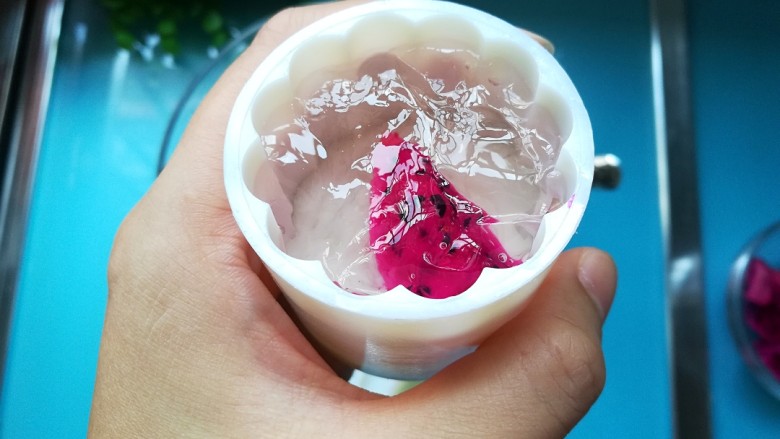 火龙果馅-果冻月饼,流动状,流动状哦,取1/3凉果放入模具,再放入一块火龙果,再放入2/3凉果,静置2-3分钟就可以脱模,也可以盖上保鲜膜放入冰箱冷冻1-2分钟取出脱模,脱模要温柔哦,容易裂开。如果做完一个后,剩下凉粉都凝固了,就再次加热融化再做第二个,以此类推