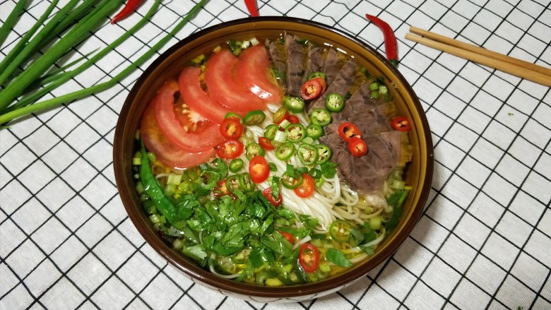 一碗让舌尖跳舞的鲜椒牛肉面,摆上牛肉,蕃茄,撒上青红椒圈,香菜叶即可