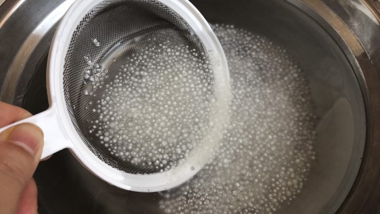 芒果椰汁西米露,利用漏筛捞起西米沥干水,倒进预先冷藏过的凉开水里,利用一冷一热的交替,使得西米口感更加Q弹,熟而不烂