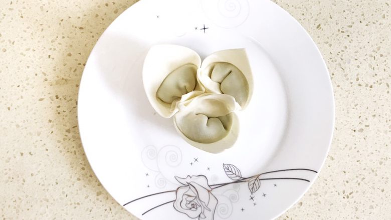#咸味#漂亮的馄饨太阳花,再包一个,如图所示,三个馄饨成三角鼎立,相互依存,立于盘中心,形成第一圈