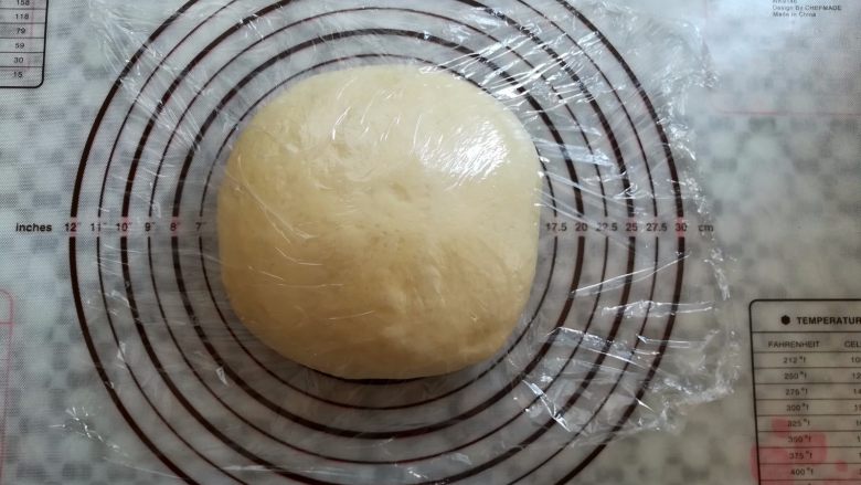 南瓜花式面包,取出面团轻压排气,滚圆盖上保鲜膜松弛15分钟,整形过程中面包机按暂停,中途启动后再次按暂停