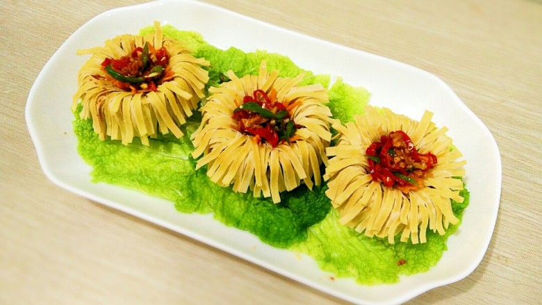 老汤辣味干豆腐,连盅把蒸好的干豆腐放入盘中,<a style='color:red;display:inline-block;' href='/shicai/ 10113'>卤汤</a>和辣椒丝蒜泥加一起搅拌均匀,浇在干豆腐盅上,即可上桌。