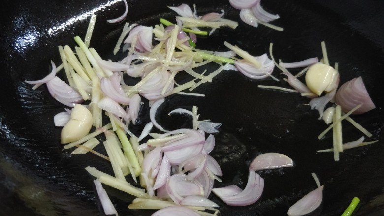 酱香茶树菇炒牛肉,锅内热少许油,放入姜、蒜、红葱头、葱白中火炒出香味。