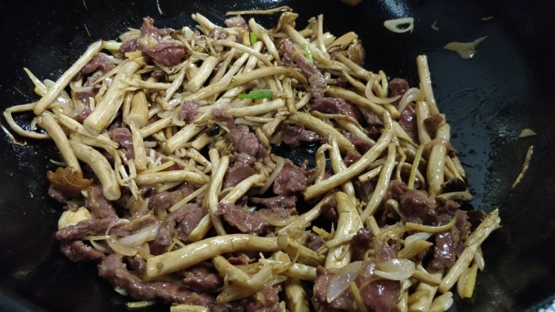 酱香茶树菇炒牛肉,加入滤干油的茶树菇大火翻炒几下,转中火加入少许酱油、耗油、盐、<a style='color:red;display:inline-block;' href='/shicai/ 762'>老抽</a>调味,转大火继续翻炒40秒。