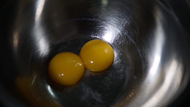 原味蛋糕卷,先分离两颗鸡蛋,蛋黄取出来,蛋白放入无水无油的另一个打蛋盆内