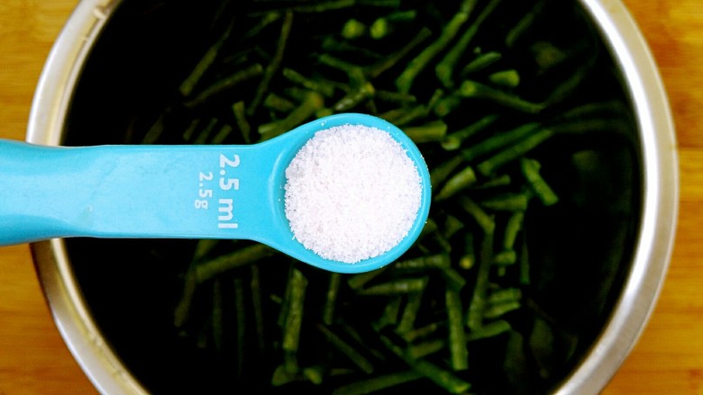 响油豇豆,把焯好的豇豆放入一个稍大的盆里,放入3g食盐。