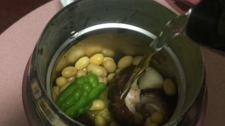 焖烧罐凉瓜黄豆排骨汤,前期焖烧罐预热的水倒掉,把焯水过的食材放入焖烧杯中,放入姜片,蒜块倒入95度以上开水至下小口处,盖上盖子顺时针拧紧放置8分钟,然后倒掉水