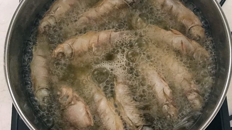 干炸鲫鱼,锅内加入大豆色拉油,油温5分热的时候加入鲫鱼,小火炸制