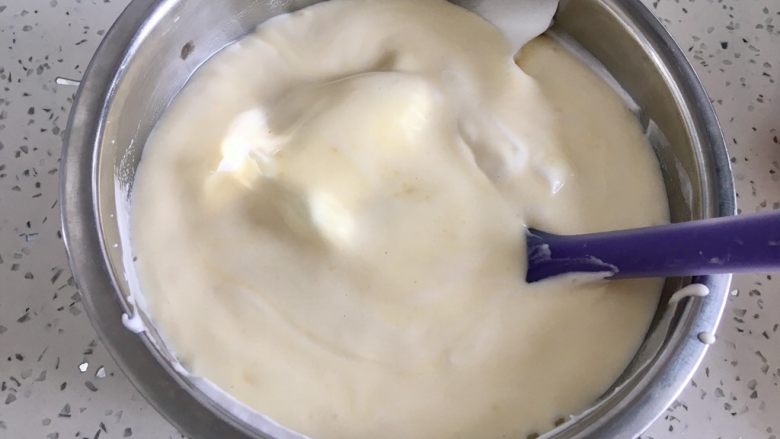 虎皮蛋糕卷,把翻拌好的蛋黄糊放入蛋白霜盆里,用刮刀翻拌均匀。