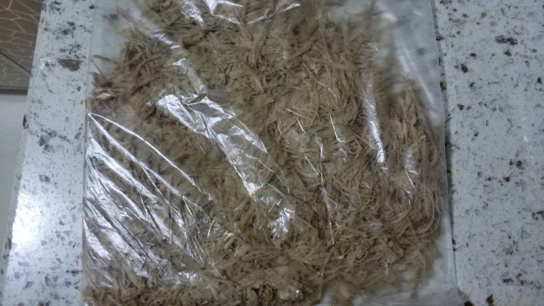 宝宝无盐牛肉松(面包机版),将撕好的肉丝放入包鲜袋中,用擀面杖擀成扁扁的(我是连锤在擀滴)