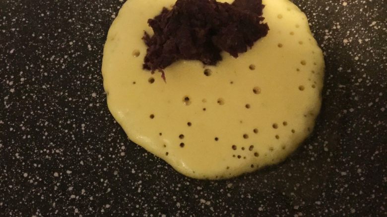 紫薯玉米面饼,一会会发现面饼有许多小孔,然后在一边放入紫薯泥