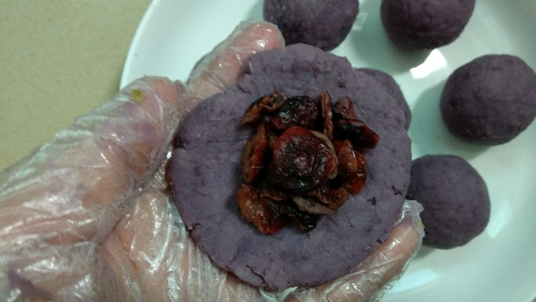 #尝过百味方叫人生##甜味#蔓越莓紫薯月饼,用手压扁包入<a style='color:red;display:inline-block;' href='/shicai/ 660'>蔓越莓</a>(5克)搓圆。