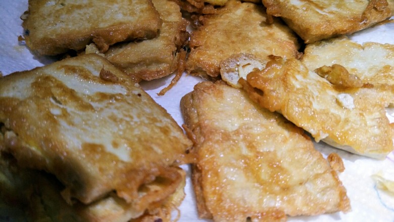 锅塌豆腐,豆腐煎透,煎至两面金黄捞出沥油,放在吸油纸上。