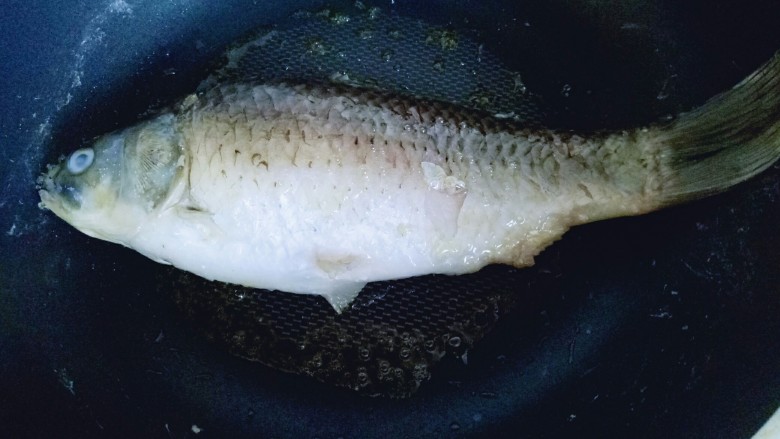#咸味#秋季补钙佳品#鲫鱼豆腐汤,平底不粘锅中加入油,放入洗干净的鱼,中小火剪至两面微黄。