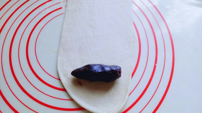 #甜味#毛毛虫豆沙面包,取一块松弛好的面团,用擀面杖擀成长舌状,再把豆沙馅放上去。(也可以把豆沙馅压扁,和面团一起擀成长舌状,根据个人喜欢来。)