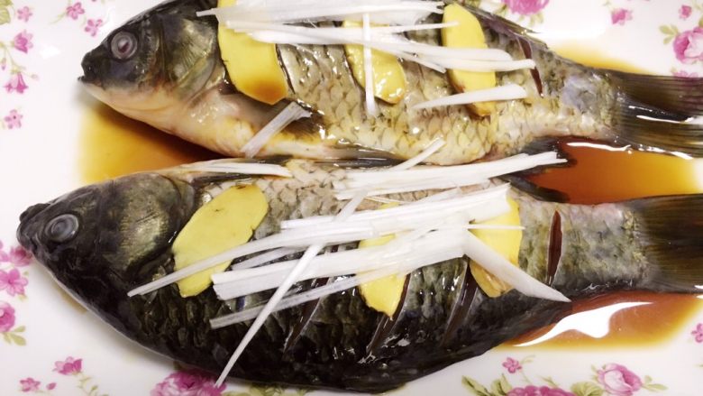 #辣菜#凉拌鲫鱼,腌制入味的鲫鱼,倒掉腌出来的水,将鱼摆盘,摆上干净姜片和大葱丝。倒入一勺<a style='color:red;display:inline-block;' href='/shicai/ 864'>蒸鱼豉油</a>。