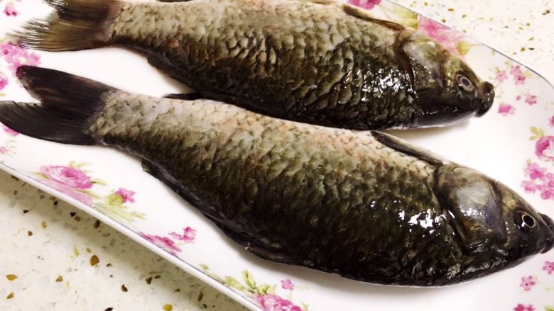 #辣菜#凉拌鲫鱼,先杀鲫鱼,去除内脏和鳞片,里外洗净后备用。