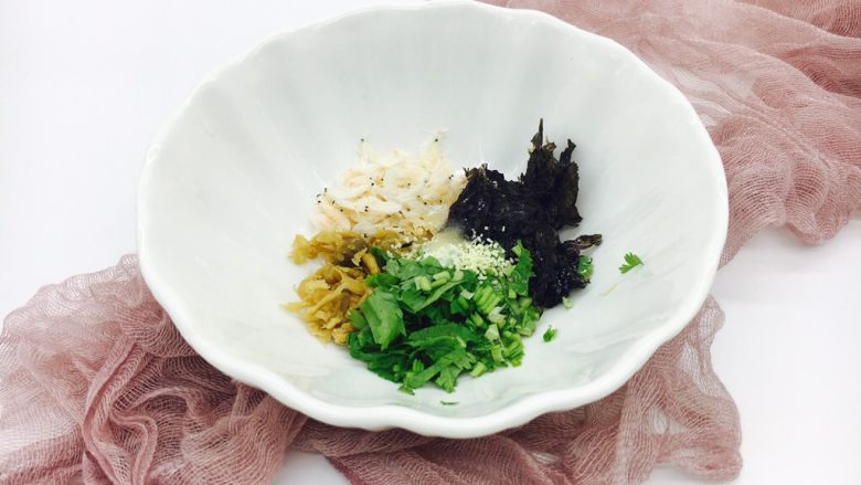 #咸味# 地方特色海鲜汤小云吞 ,把紫菜,香菜,小虾皮,冬菜放在汤碗里,再倒入1小勺的香油,放入少许白胡椒,<a style='color:red;display:inline-block;' href='/shicai/ 756'>鸡精</a>,盐。