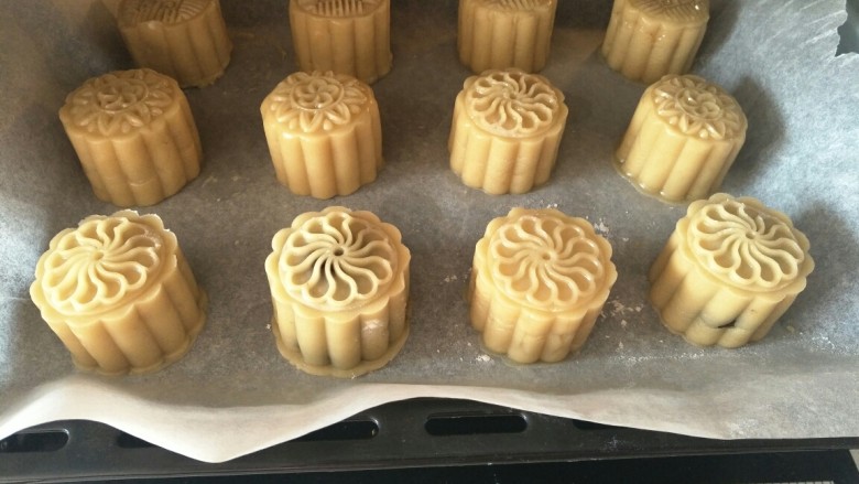 广式莲蓉蛋黄馅月饼,放入预热好的烤箱,上下火中层200°烤3~4分钟定下型