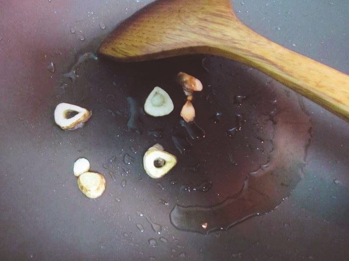番茄巴沙鱼(龙利鱼)更好吃的秘诀!,中火加热炒菜锅,待锅热后加入适量的玉米油,放入大蒜翻炒,等炒香微焦的时候倒入番茄块翻炒,在炒的同时可以用锅铲压一下番茄块,让它更容易变成糊状。(放番茄的时候我又忘记拍照了原谅我😂)