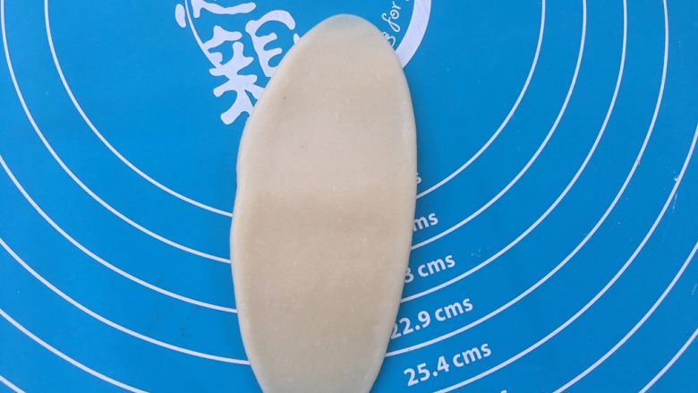 全面详细讲解~蛋黄酥,用擀面杖将油皮包裹油酥的小圆球擀成牛舌状态。