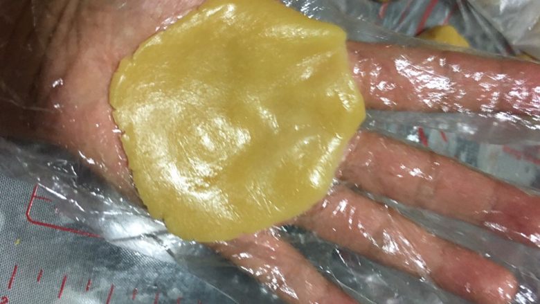 蔓越莓椰蓉月饼,取一块面皮,用手掌轻轻的压扁