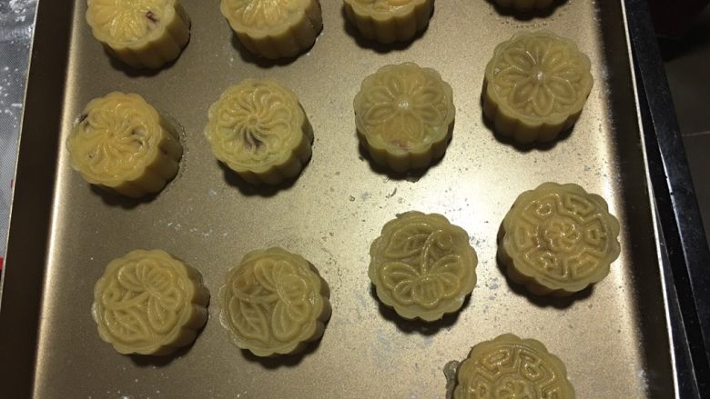 蔓越莓椰蓉月饼,拿出来刷第一次蛋液,用毛刷轻轻的刷凸起的部分,烤箱165度烤10分钟