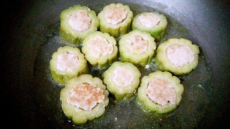 客家美食酿苦瓜,放入苦瓜煎至两面微黄,倒入适量清水,中火焖煮