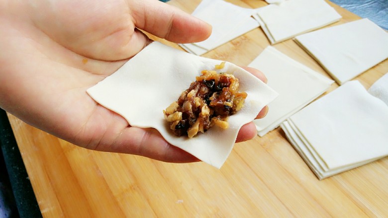 石蛤蟆水饺(博山水饺的包法),开始包饺子,将饺子皮放在伸平的左手掌上,梯形的上底(小头)朝指尖方向。将馅料放在小头的一端。