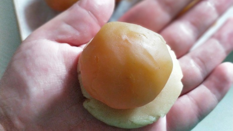 莲蓉蛋黄月饼,将面团按20克每个分好,按扁包裹馅儿,同样是轻推至完全包裹。