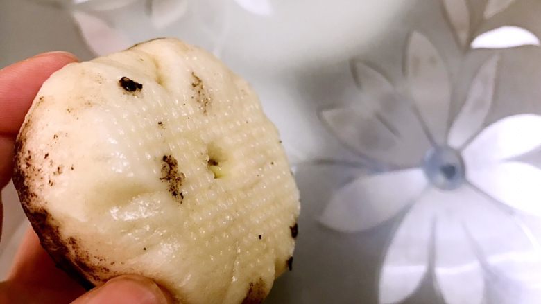 脑洞大开的榴莲馅蘑菇包,蒸好后稍微晾凉,去一个蘑菇包用筷子在底部戳一个孔