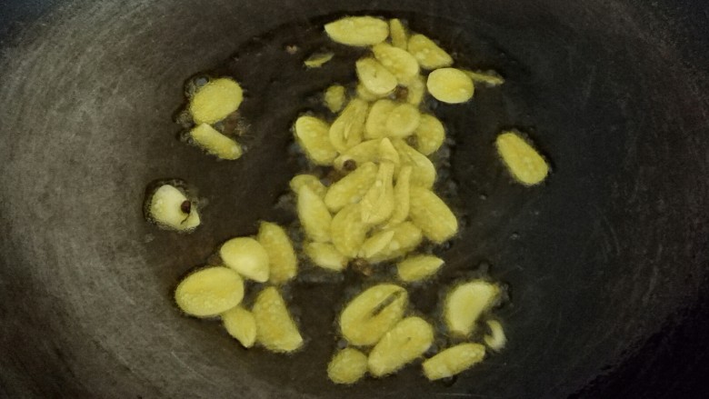 五香土豆串,锅里放入适量的油烧热后,放入花椒、蒜片,煸出香味,即可关火