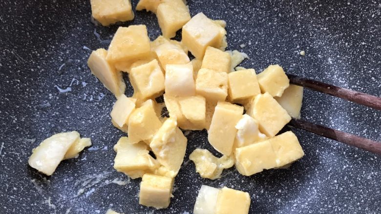 西红柿杂蔬炒馒头,油热后倒入馒头丁,翻炒均匀。