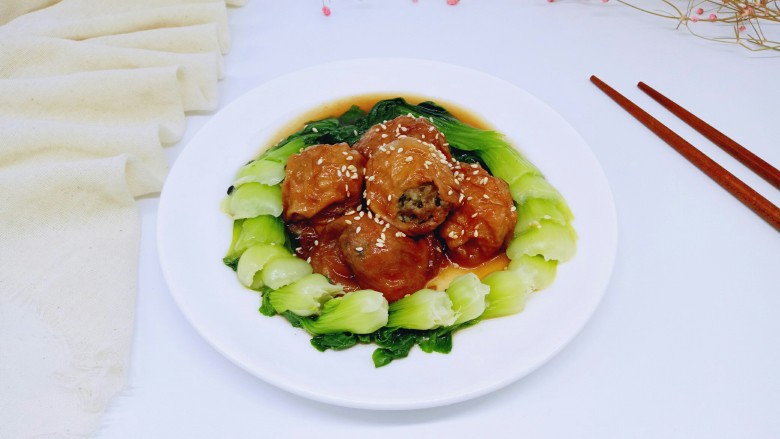 #咸味#美味的面筋塞肉#,装盘撒上<a style='color:red;display:inline-block;' href='/shicai/ 141911'>熟白芝麻</a>,将焯过水的青菜,摆放在盘子里,将面筋塞肉围一圈。