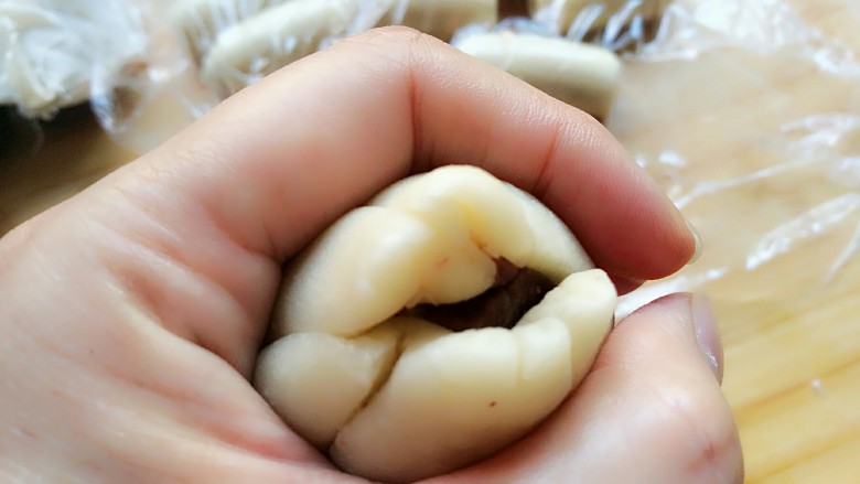蛋黄酥,在手掌虎口处大拇指和食指转圈慢慢向上推捏把口收紧。