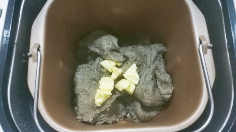 红糖黑芝麻叶子软欧,加入软化的黄油,继续揉面至完全扩展阶段;