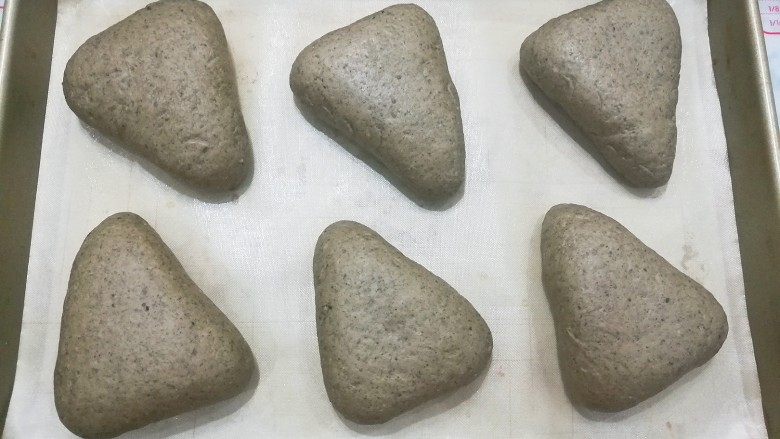 红糖黑芝麻叶子软欧,依次做好所有的小面团,摆入烤盘中盖保鲜膜进行二发;
