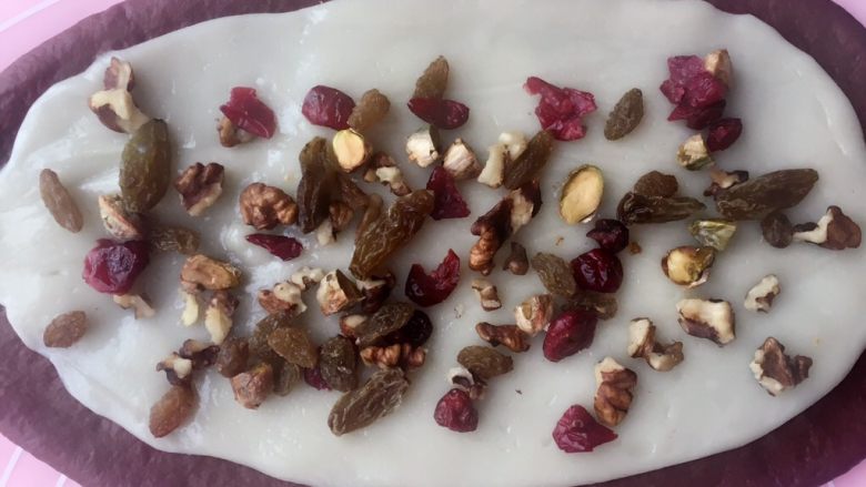可可麻薯软欧包,面团擀薄
铺上同时擀好的麻薯
撒上适量的果干
PS:操作麻薯的时候戴一次性手套,砧板上,擀面杖上铺上裹上保鲜膜,可以更好的操作;