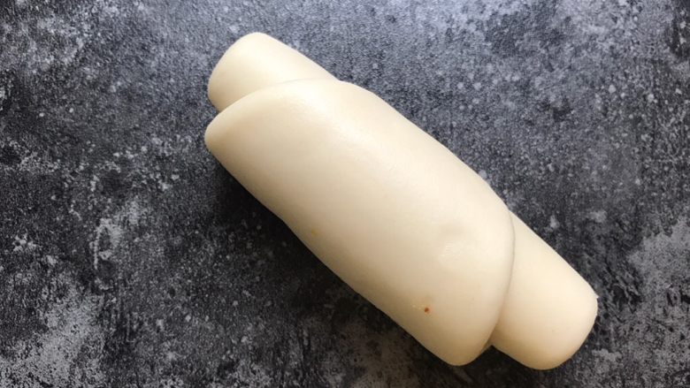 龙虎斗烧饼,将圆形的面团擀成长条形,从一头慢慢像另一头卷起。