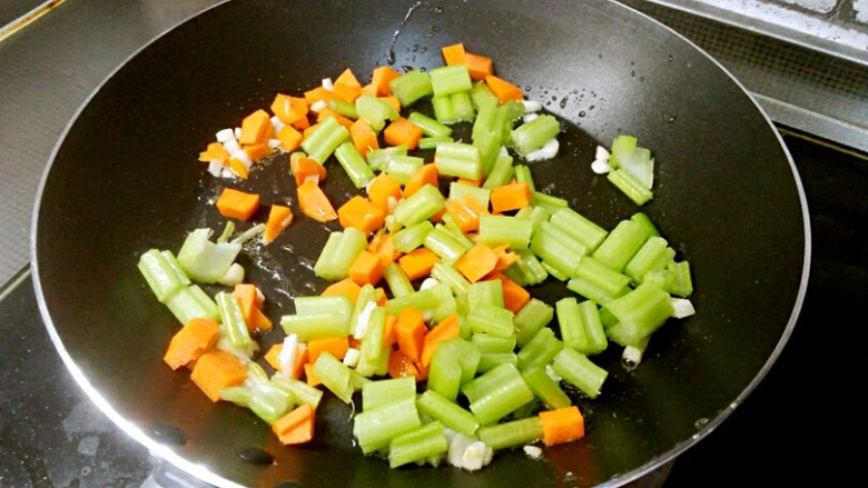 芹菜鸡蛋炒虾仁,将芹菜和胡萝卜加入锅中。