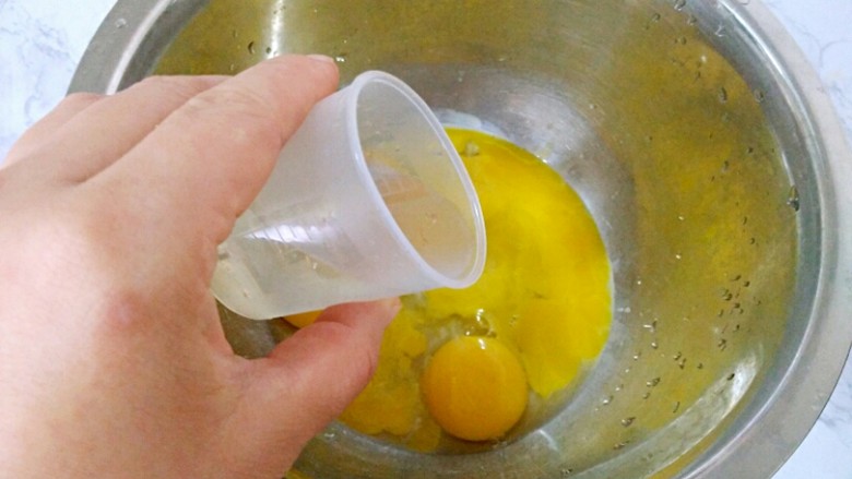 戚风蛋糕(八寸),蛋黄中加入水,拌匀