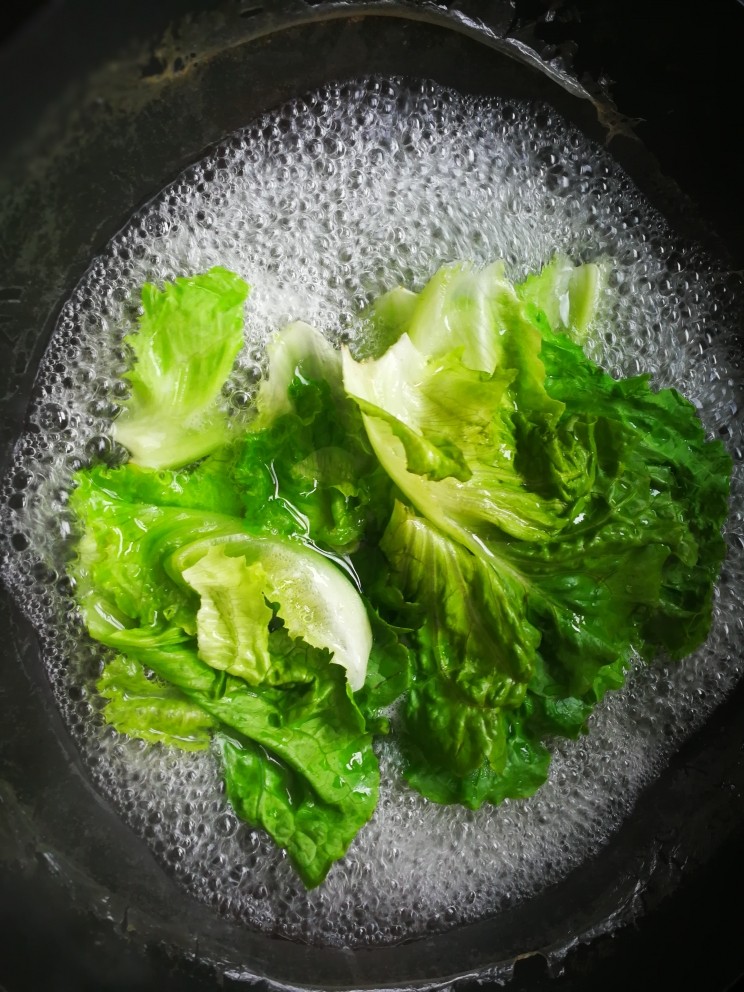 麻辣卤汤牛肉面,锅里烧开水,放生菜焯至变翠绿捞出。