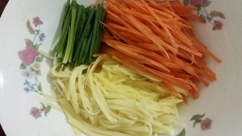 黄金田园菜饼,胡萝卜丝、土豆丝、香葱节、鸡蛋液放到一个大碗里